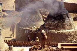 Image du Maroc Professionnelle de  Un ouvrier pétrit  l’argile imprégnée d’eau dans les ateliers de la Vallée Chaâba près des fours où l’on procède à la cuisson des poteries en céramique à Safi, Souvent les artisans ont recours à leur dextérité afin de fignoler la décoration à Safi, Samedi 30 Août 1997. (Photo / Abdeljalil Bounhar) 